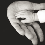 Kind hält die Hand seiner Eltern. Starke Familien durch die Transaktionsanalyse