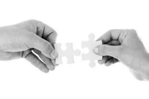 Zwei Hände halten jeweils ein Puzzlestück - Mediation verbindet